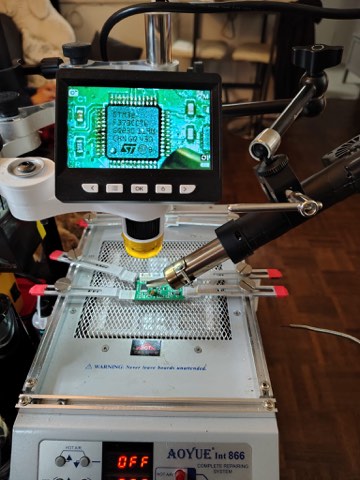 Resoldering the STM32 microcontroller under magnification.